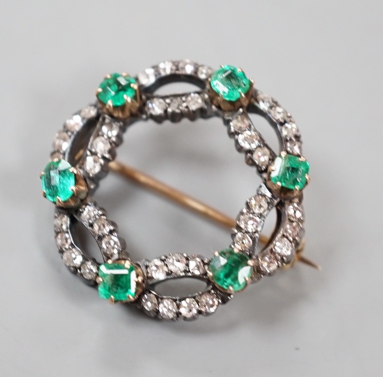 A late Victorian yellow and white metal, emerald and diamond cluster set open work brooch, 21m, gross weight 4.3 grams.